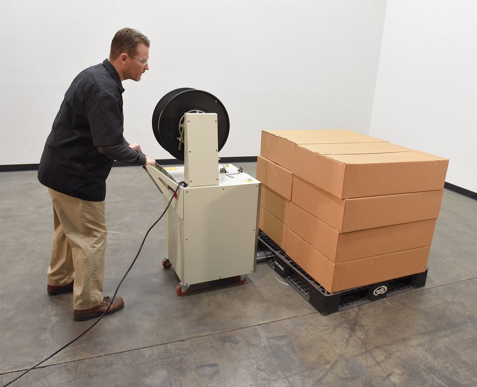 Worker securing boxes on pallet