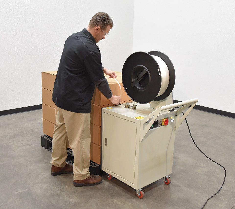 Man using strapping machine on boxes
