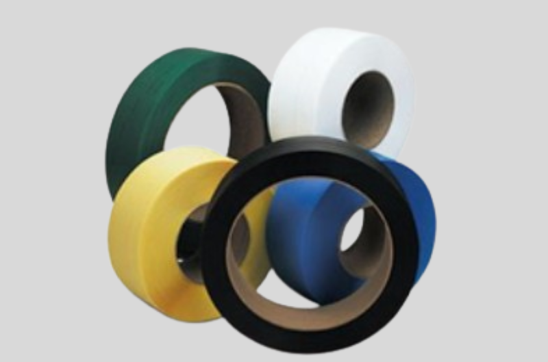 Multicolored industrial strapping rolls on gray background