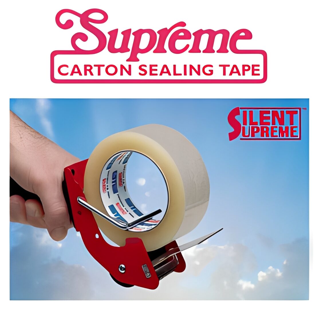 Hand holding tape dispenser with packing tape